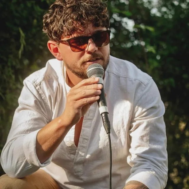 speaking into a microphone at a festival